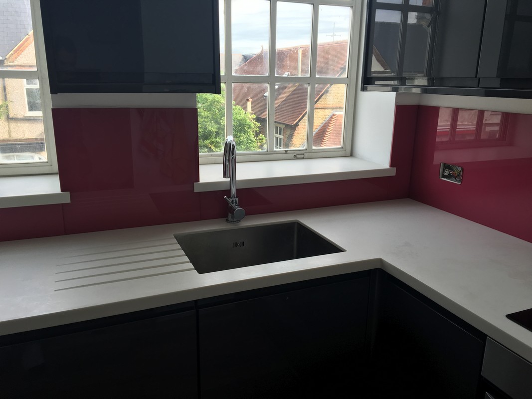 Deep plum coloured glass splashback in modern Beaconsfield kitchen